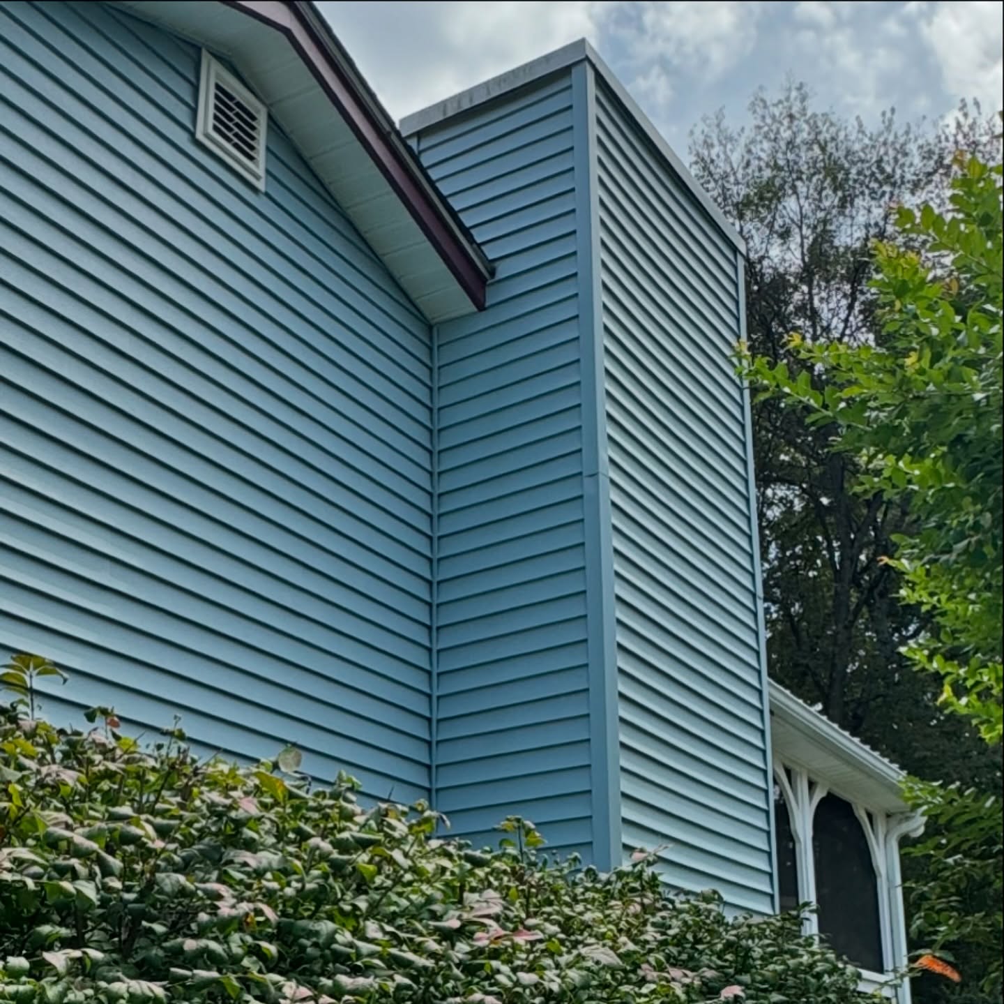Clean light-blue lap siding on a residential home after soft washing